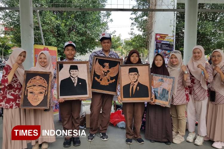 Guru dan murid SLB Al Fir Ma'unah Jabung Malang saat menunjukkan kriya kayu siluet, karya murid mereka dari kalangan anak berkebutuhan khusus (ABK), di sebuah pameran di Malang. (Foto: Achmad Fikyansyah/TIMES Indonesia)