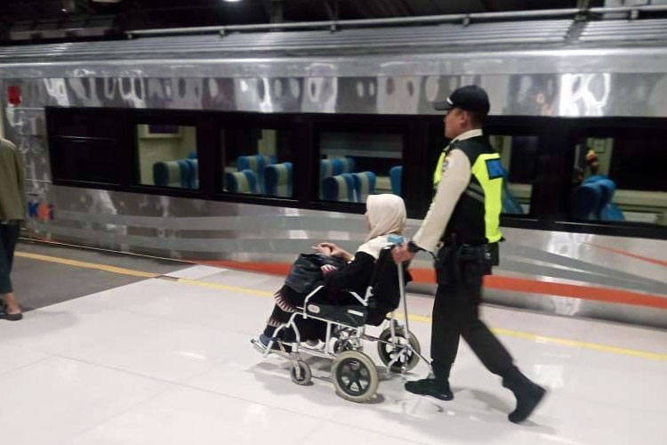 Seorang anggota  Satpam saat mendorong calon penumpang difabel yang akan menaiki salah satu KA di stasiun Bandung, Senin (13/10/2025) (FOTO: Humas Daop 2 Bandung)