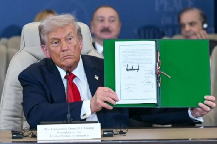 Presiden AS, Donald Trump saat menunjukkan dokumen yang ditandatangani selama pertemuan puncak mengenai Gaza di Sharm el-Sheikh pada 13 Oktober 2025.(FOTO: Al Jazeera/AFP)