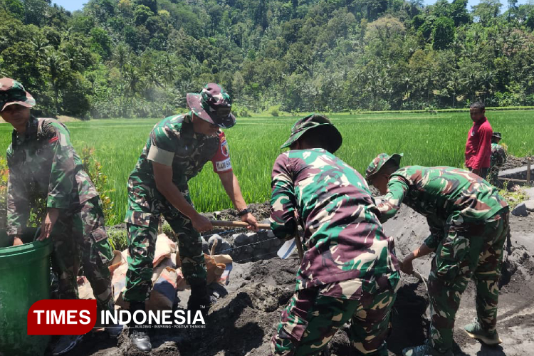 Suasana saat personel TNI dan warga mengerjakan pembangunan irigasi di Desa Lebakharjo, Ampelgading, Kab Malang. Dandim 0818 Malang/Batu, Letkol Czi Bayu Nugroho, juga ikut bekerja. (Foto: Yatimul Ainun/TIMES Indonesia).