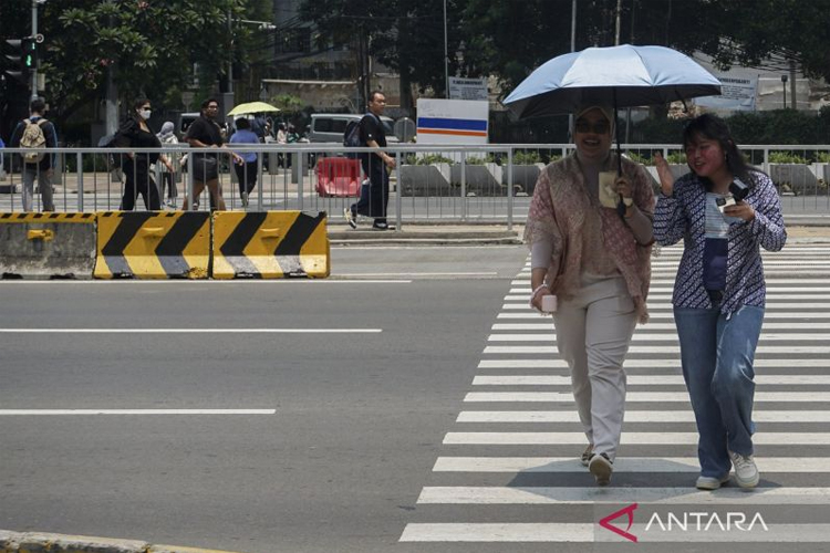 Warga melintasi pelican crossing di Jakarta, Kamis (9/10/2025). Badan Meteorologi, Klimatologi, dan Geofisika (BMKG) menyatakan suhu panas di Indonesia akan bertahan hingga awal November 2025. (foto: Antara/Ika Maryani)