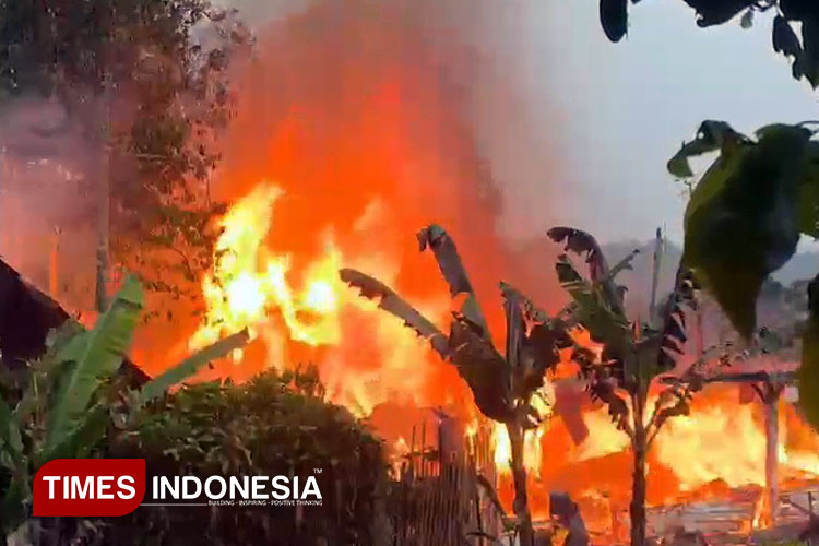 Kobaran api dari rumah warga Desa Belik, Kecamatan Belik, petugas damkar perempuan sedang memadamkan api ( Foto: Ragil/TIMES Indonesia)