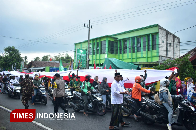 Diterpa Hujan Deras, Ribuan Santri Tetap Semangat Arak Bendera NU dan Merah Putih hingga Makam Muassis Pendiri NU