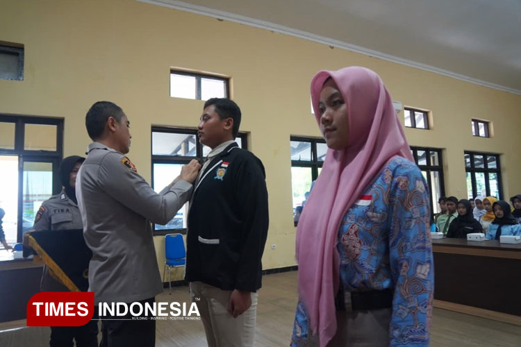 Penyematan pin kepada perwakilan pengurus OSIS sebagai mitra polisi dalam mendiagnosis masalah sosial oleh Kapolres Pacitan AKBP Ayub Diponegoro Azhar. (FOTO: Yusuf Arifai/TIMES Indonesia)