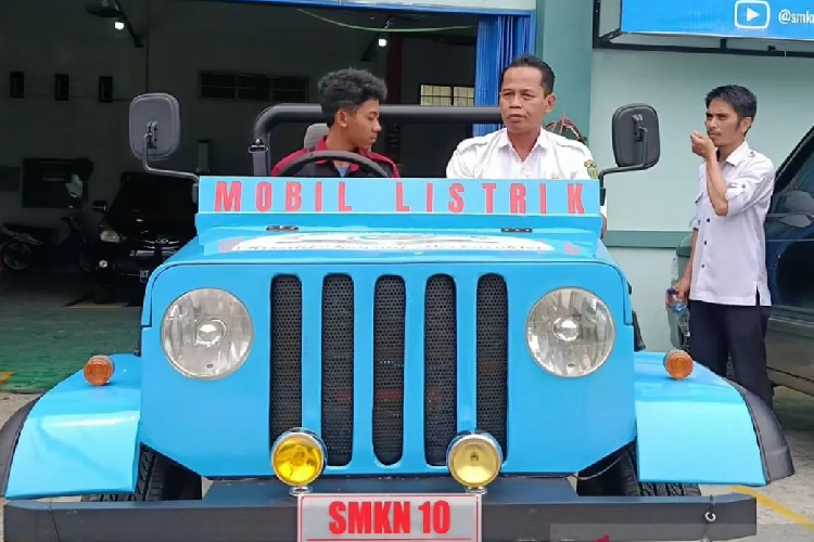 Kepala SMKN 10 Samarinda Maryono duduk di mobil listrik bersama siswanya. (FOTO: ANTARA/Ahmad Rifandi)