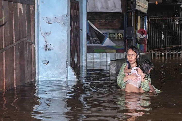 Ilustrasi - Warga menggendong anaknya saat menerobos banjir di kawasan Petogoan, Kebayoran Baru, Jakarta, Kamis (30/10/2025). (FOTO: ANTARA FOTO/Sulthony Hasanuddin/nym)