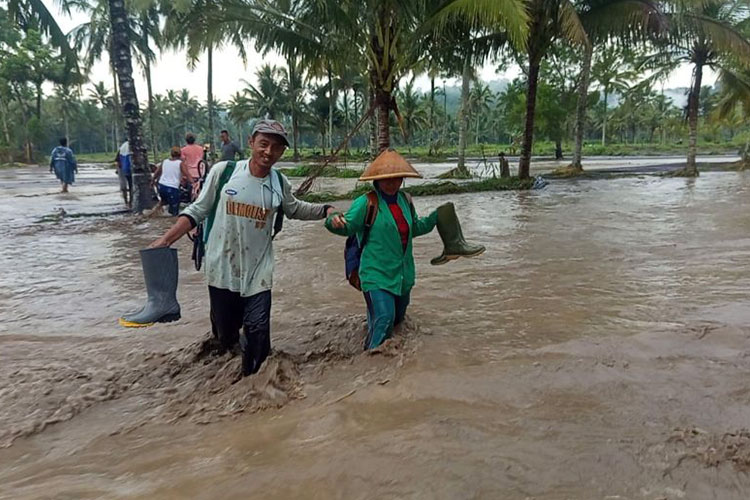Sejumlah warga nekat melintas saat banjir lahar hujan Gunung Semeru di Desa Gondoruso, Rabu (5/11/2025). (Foto: Relawan BPBD Lumajang)