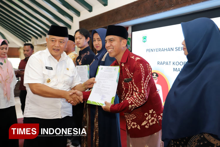 Bupati Malang H. Sanusi saat menyerahkan simbolis SLHS kepada pengelola SPPG yang sudah beroperasi di Kabupaten Malang, Jum'at (7/11/2025). (Foto: Prokopim/TIMES Indonesia)