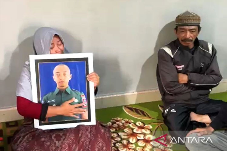 Orang tua dari Prajurit Dua (Prada) HMN memegang foto anaknya di rumah duka. HMN meninggal dunia karena diduga dianiaya seniornya pada tempatnya bertugas di C Yonarhanud 4/AAY, Kabupaten Gowa, Sulawesi Selatan.   (FOTO: ANTARA/Darwin Fatir)