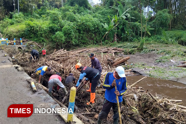 Petugas bersama masyarakat bersama-sama membersihkan material yang terbawa banjir luapan Sungai Amprong, di Wonorejo Desa Ringinanom Poncokusumo Kabupaten Malang, Minggu (9/11/2025). (Foto: BPBD Kabupaten Malang for TIMES Indonesia)