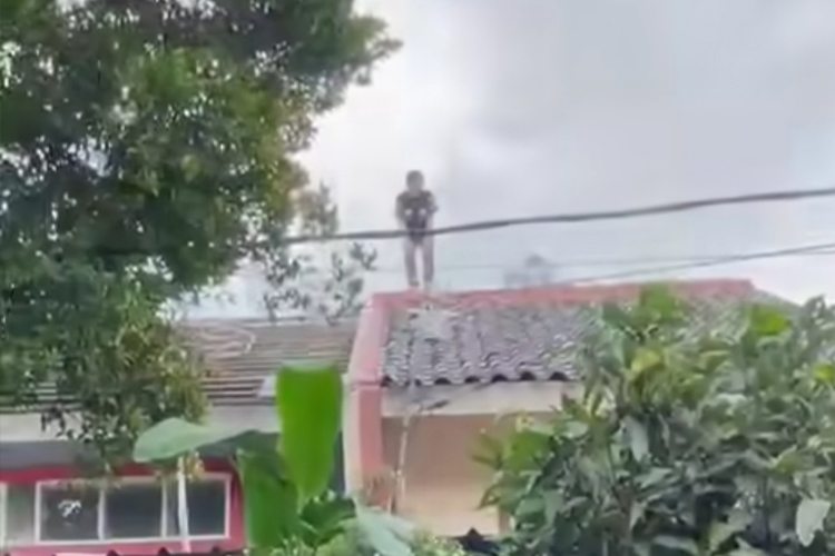 Detik-detik pria yang diduga pencuri nekat kabur ke atap rumah warga. (foto: tangkapan layar)