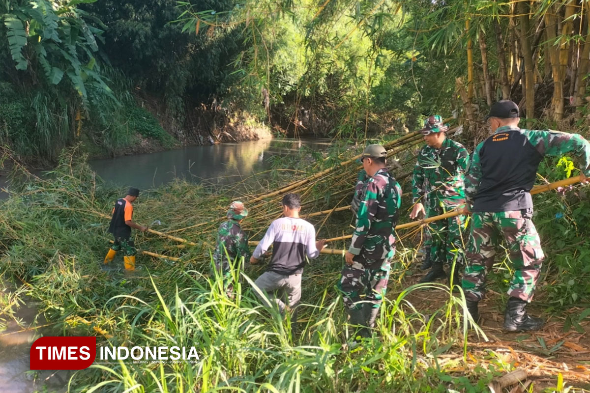 Anggota Kodim 0082/Ponorogo Bersihkan Rumpun Bambu untuk Lokasi Pembangunan Jembatan Gantung